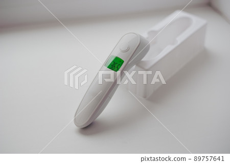 Non-contact thermometer on a white background for measuring body temperature 89757641