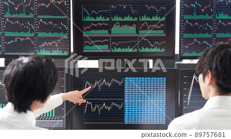 Rear view of a business person pointing at the screen of multiple monitors Trader image Rear view of a business person pointing at the screen of multiple monitors Trader image 89757681