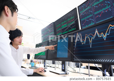 指著多台顯示器屏幕講話的商務人士 89757685