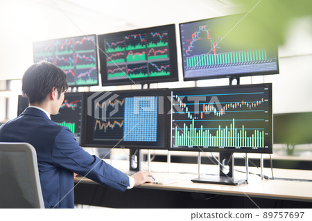 坐在多顯示器 PC 前的商務人士交易員的圖像 89757697