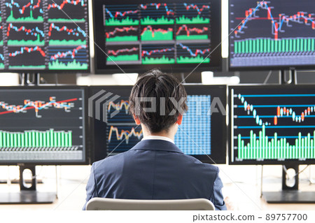 Rear view of a business person looking at the screen of multiple monitors Trader image 89757700