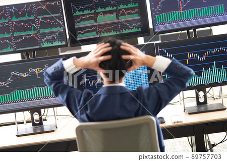 一名男子在查看多顯示器圖表時抱著頭的後視圖 Trader image 一名男子在查看多顯示器圖表時抱著頭的後視圖 Trader image 89757703