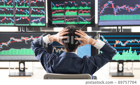 一名男子在查看多顯示器圖表時抱著頭的後視圖 Trader image 一名男子在查看多顯示器圖表時抱著頭的後視圖 Trader image 89757704