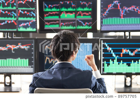 Rear view of a man doing a guts pose while looking at a multi-monitor chart Trader image Rear view of a man doing a guts pose while looking at a multi-monitor chart Trader image 89757705