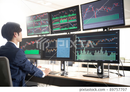 Image of a business person trader looking at the screen of multiple monitors Image of a business person trader looking at the screen of multiple monitors 89757707