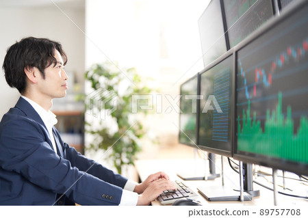 Image of a business person trader looking at the screen of multiple monitors 89757708