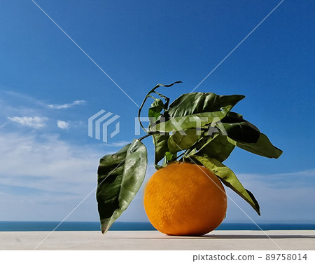 orange with green leaves on a light marble table, blue sea and sky background, copy space, greeting card, postcard, banner, cover, mockup, for your design orange with green leaves on a light marble table, blue sea and sky background, copy space, greeting card, postcard, banner, cover, mockup, for your design 89758014