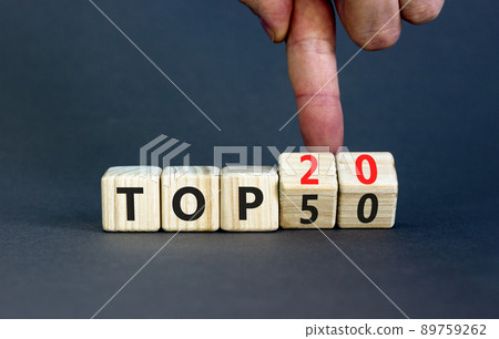 From Top 50 to 20 symbol. Businessman turns wooden cubes and changes concept words Top 50 to Top 20. Beautiful grey table grey background. Business and from Top 50 to Top 20 concept. Copy space. 89759262
