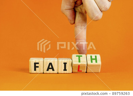 Faith instead fail symbol. Businessman turns wooden cubes and changes the concept word Fail to Faith. Beautiful orange table orange background. Business and faith instead fail concept. Copy space. 89759263