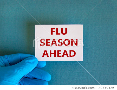 Hand in blue glove with white card. Concept words 'flu season ahead'. Medical and Coronavirus COVID-19 protection concept. Copy space, beautiful blue background. Hand in blue glove with white card. Concept words 'flu season ahead'. Medical and Coronavirus COVID-19 protection concept. Copy space, beautiful blue background. 89759326