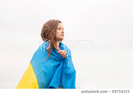 A little girl with the flag prays for the victory 89759355