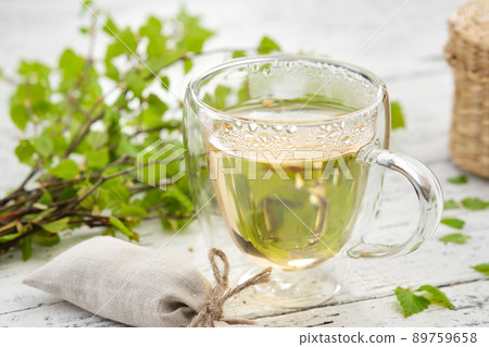 Healthy herbal tea cup, twigs of Birch tree with leaves. Alternative herbal medicine. 89759658