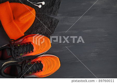Orange sneakers, an orange knitted hat, warm leggings for sports and white headphones Orange sneakers, an orange knitted hat, warm leggings for sports and white headphones 89760011