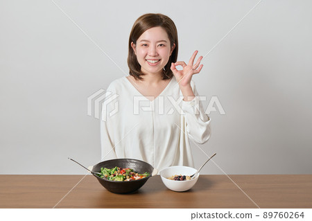 Young woman posing OK before eating salad and oatmeal Young woman posing OK before eating salad and oatmeal 89760264