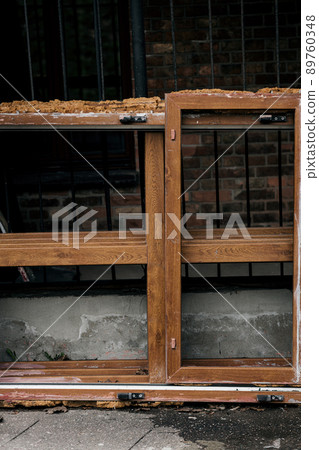 broken old window next to a ruined house broken old window next to a ruined house 89760348