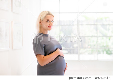 Pregnant woman at home. Young expecting mother. 89760812