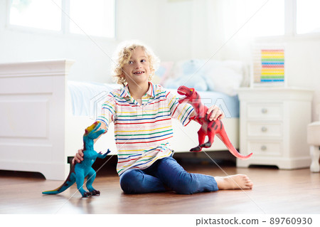 Child playing with toy dinosaurs. Kids toys. 89760930