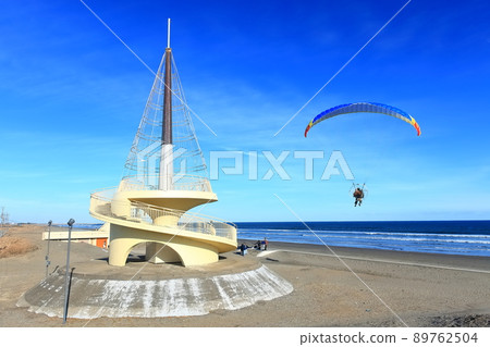 [Chiba] Kujukuri Beach Tower and motor paraglider under sunny weather 89762504