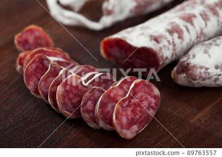 Slicing delicious Spanish smoked sausage fuete Slicing delicious Spanish smoked sausage fuete 89763557