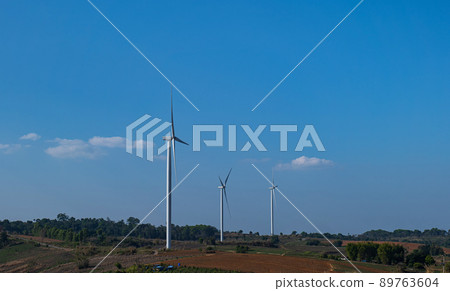 Wind turbine farm on mountain landscape with blue sky background. Wind power renewable energy concept. 89763604