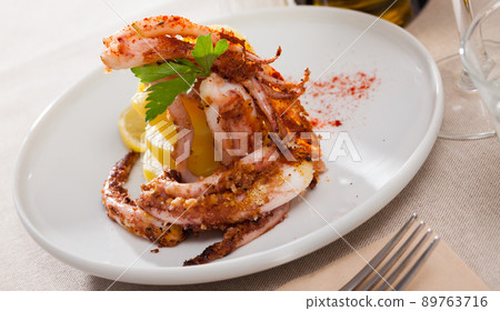 Fried tentacles squid with potatoes 89763716