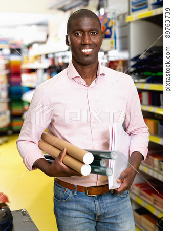 African american male customer choosing paper office supplies in stationery shop African american male customer choosing paper office supplies in stationery shop 89763739