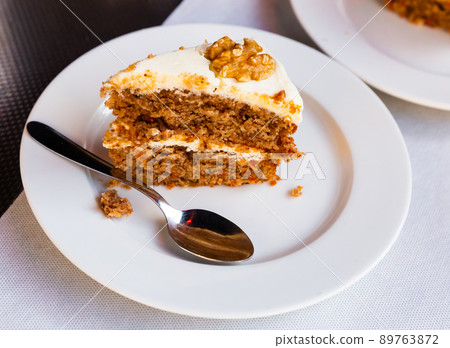 Slice of soft carrot cake with cream cheese glaze on wooden table Slice of soft carrot cake with cream cheese glaze on wooden table 89763872