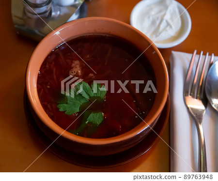 Traditional Ukrainian red borscht in meat broth with greens 89763948