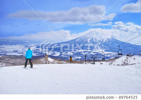 Niseko ski resort for spring skiing, skiers and snowboarders before skiing looking at the skiing course from now on Niseko ski resort for spring skiing, skiers and snowboarders before skiing looking at the skiing course from now on 89764525