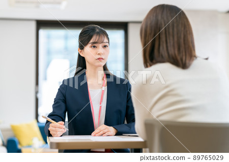A serious young business woman who consults with middle-aged women A serious young business woman who consults with middle-aged women 89765029