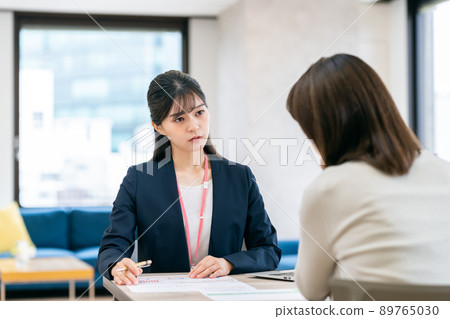 A serious young business woman who consults with middle-aged women A serious young business woman who consults with middle-aged women 89765030