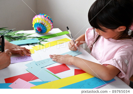 Sisters writing wishes on strips 89765034