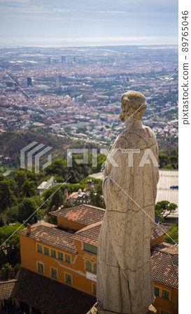 Barcelona, Spain - September 23, 2021: Stone statue on the roof of the Church of the Sacred Heart of Jesus on the summit of Parc Tibidabo. Cathedral sculptures, aerial view,  focus on the statue 89765046