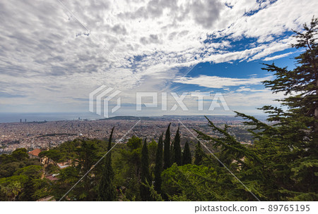 Aerial view over the skyline of Barcelona, Spain. Panoramic wide angle view from the summit Mount Tibidabo. The mediterranean Sea on the horizon 89765195