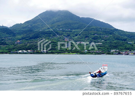Kannon Mountain and Small Boat in Tamsui, Taiwan 89767655