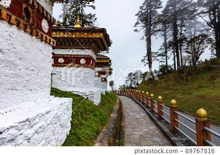 Bhutan, October 26, 2021: Druk Wangyal, Bhutan, 108 chorten or stupas, memorial in honor of the Bhutanese soldiers at the Dochula Pass. Cloudy foggy day in altitude of 3000 meters. Bhutanese sanctuary Bhutan, October 26, 2021: Druk Wangyal, Bhutan, 108 chorten or stupas, memorial in honor of the Bhutanese soldiers at the Dochula Pass. Cloudy foggy day in altitude of 3000 meters. Bhutanese sanctuary 89767816