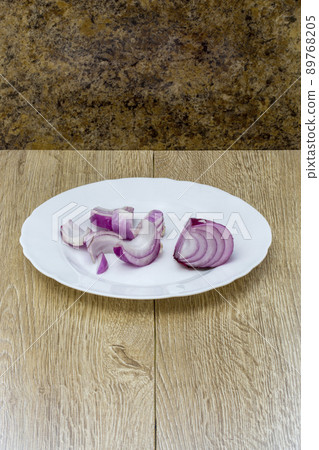 Sliced purple onion close-up on a white plate 89768205