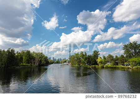 The skyline of Toronto, a view from the lake side - Toronto, Ontario, Canada. Panorama view of the Canadian city of Toronto, with white clouds on a blue sky with the Toronto tower. Urban view of city The skyline of Toronto, a view from the lake side - Toronto, Ontario, Canada. Panorama view of the Canadian city of Toronto, with white clouds on a blue sky with the Toronto tower. Urban view of city 89768232