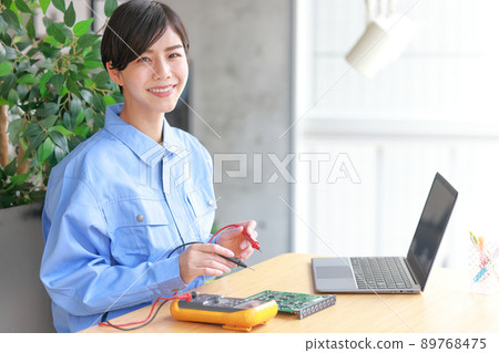 Woman with tester lead of circuit tester 2 89768475