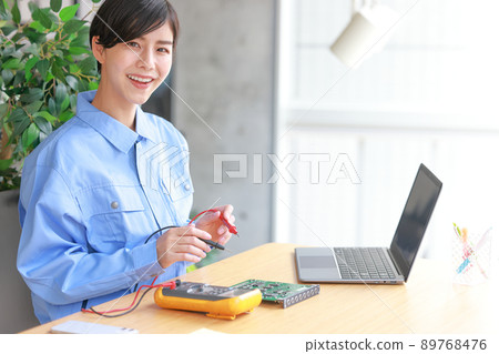 Woman with tester lead of circuit tester 3 89768476