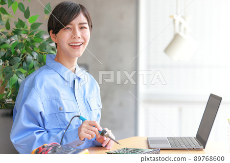 Board maintenance_Smiling woman with a soldering iron 2 89768600
