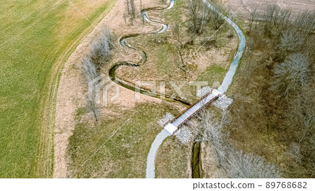 Aerial view in springtime with a trail and spiraling river Aerial view in springtime with a trail and spiraling river 89768682