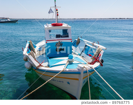 Tinos, Greece - July 02, 2021: Traditional Fisher boat in the harbor of Tinos, a Greek island situated in the Aegean Sea. It is located in the Cyclades archipelago. Anciently, the island called Tenos. 89768775