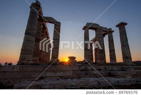 Amazing colorful sunset at the Temple of Poseidon, archaeological site of Sounion, Attica. Cape Sounion, Lavrio, Greece. A sunset behind the citadel on a hill at the shoreline of Mediterranean Sea. 89769376
