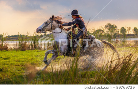 Cowboys riding horses beside the river and lifestyle with natural light background. 89769729