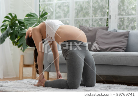 Happy Attractive Asian Pregnant woman practice yoga Ustrasana pose or yoga Camel pose to meditation smile with big belly after wake up in morning comfortable and relax.Pregnant yoga concept Happy Attractive Asian Pregnant woman practice yoga Ustrasana pose or yoga Camel pose to meditation smile with big belly after wake up in morning comfortable and relax.Pregnant yoga concept 89769741