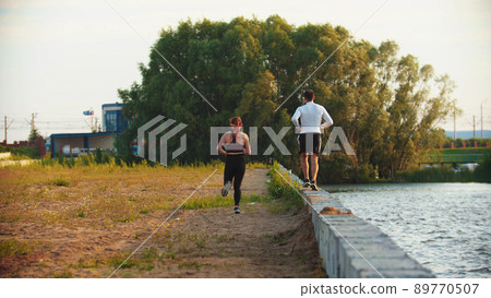 Man and woman jogging on the waterfront Man and woman jogging on the waterfront 89770507
