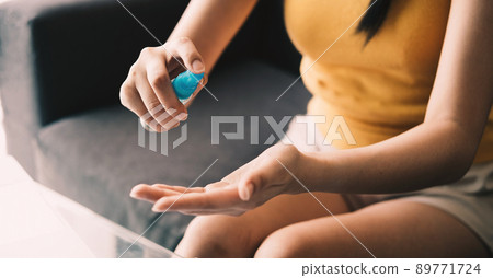 Close up hand of lady that applying alcohol spray or anti-bacteria spray to prevent the spread of germs, bacteria and virus. Personal hygiene concept 89771724