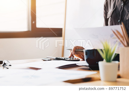 Close up Business woman using calculator and laptop for do math finance Close up Business woman using calculator and laptop for do math finance 89771752