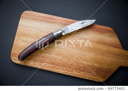 Traditional pocket knife on a wooden cutting board Traditional pocket knife on a wooden cutting board 89773401